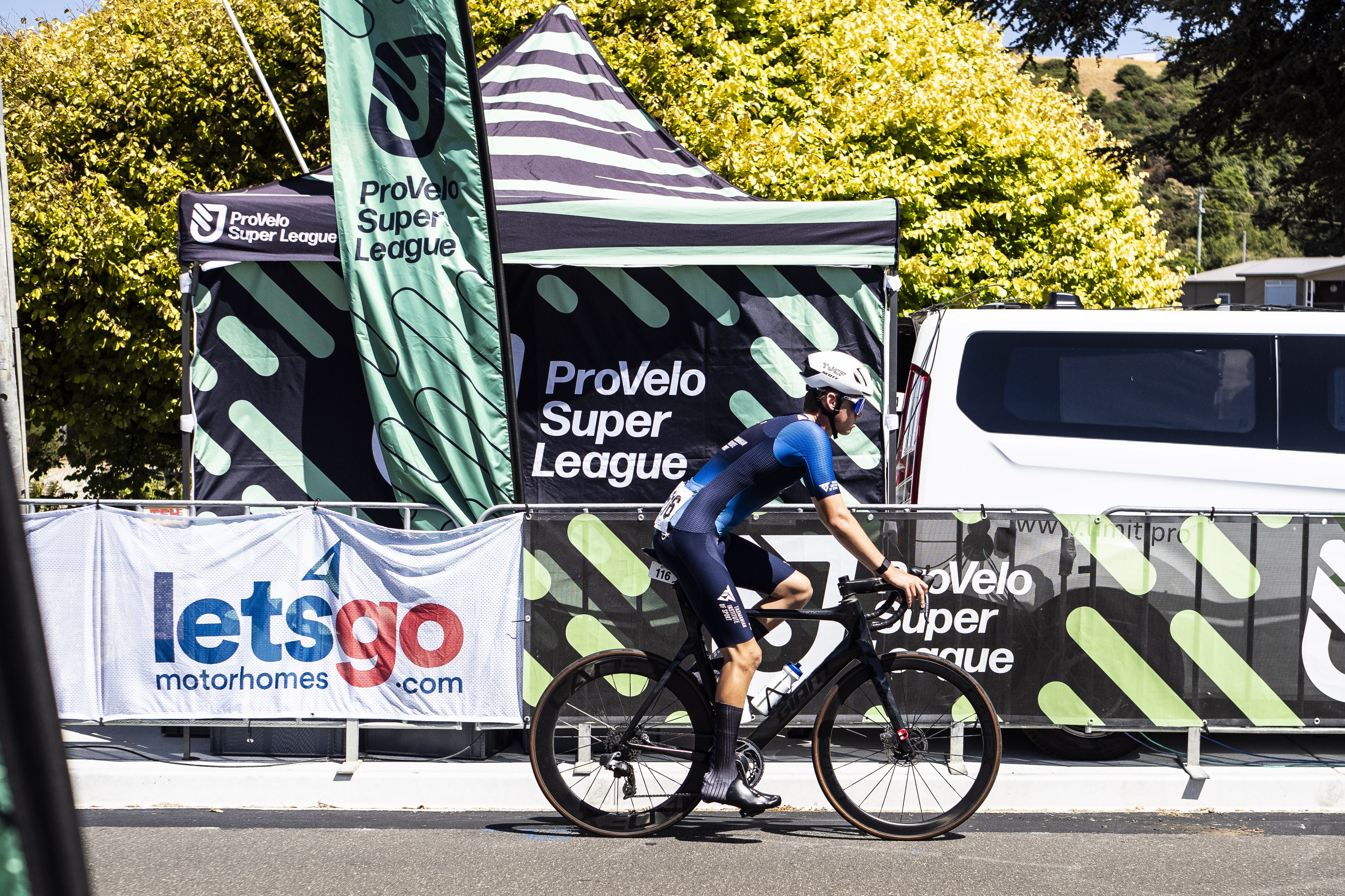 A cyclist rides past the ProVelo Super League PSL banner